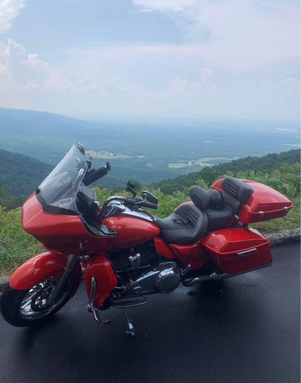Custom shaved and covered Harley-Davidson touring seat featuring grey perforated material, orange stitching, matching rider backrest, and dual Tour-Pak cushions